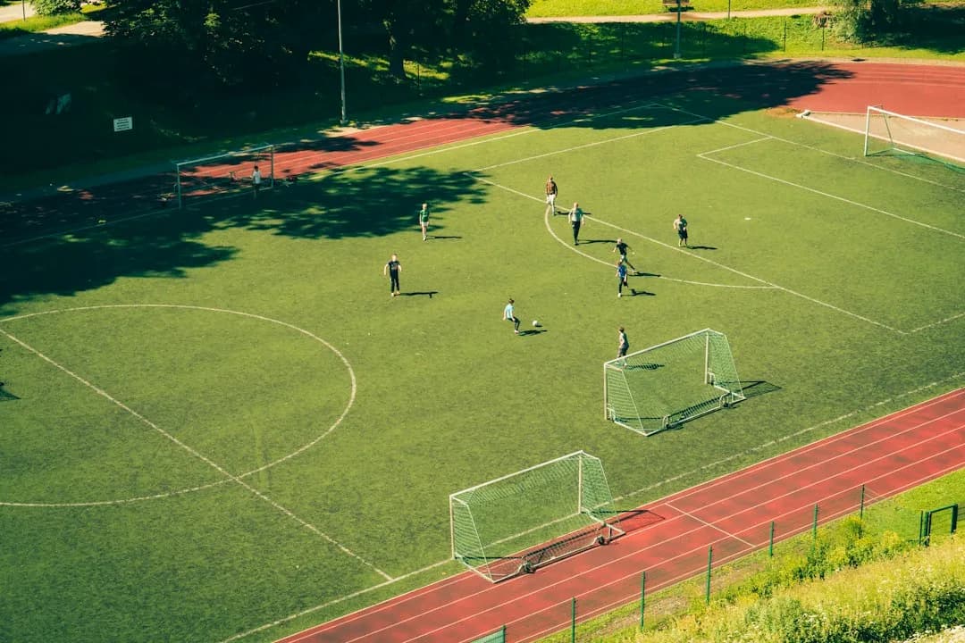 Fotbollsmatch på en grön plan sedd ovanifrån