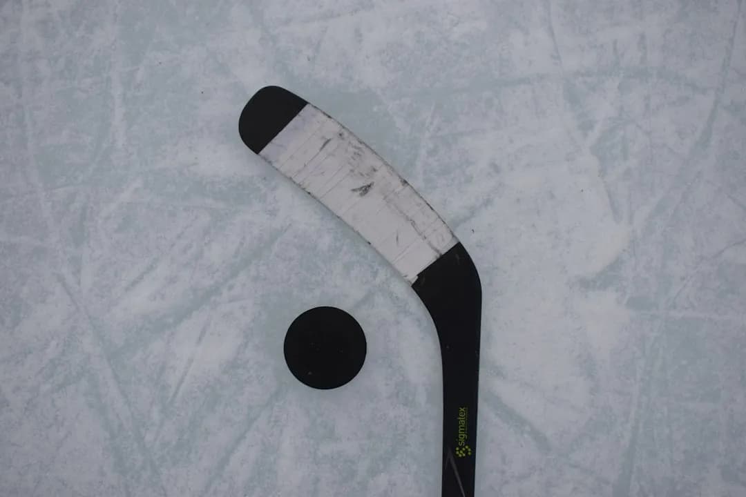 Ishockeyklubba och puck på isen