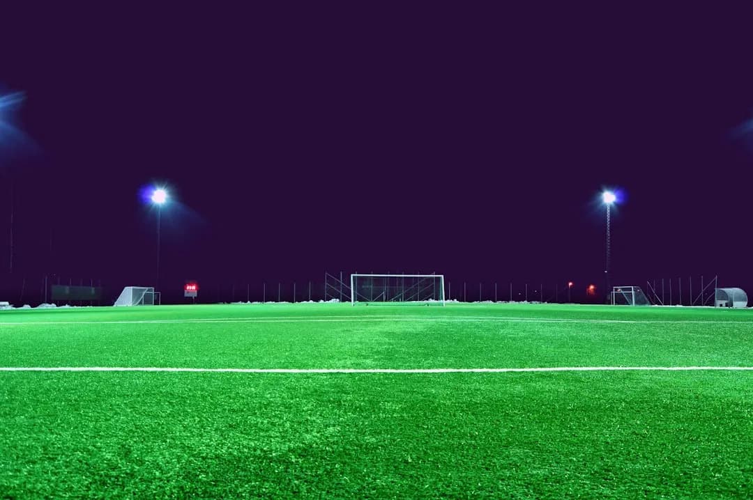 Fotbollsplan i strålkastarljus visad på en TV i 4K